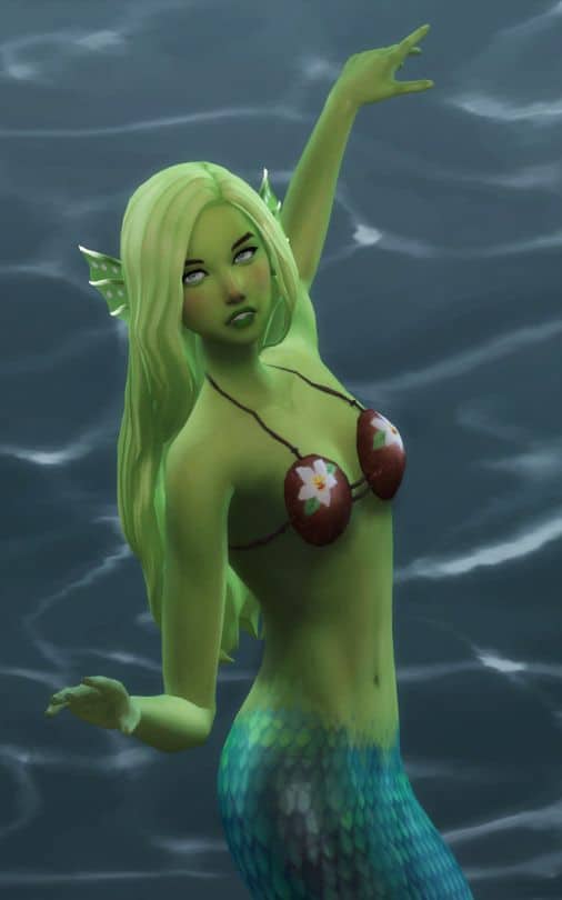 green mermaid posing in water