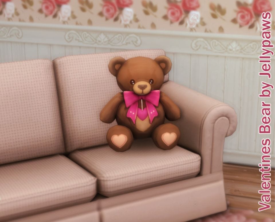 teddy bear with pink bow sitting on a couch