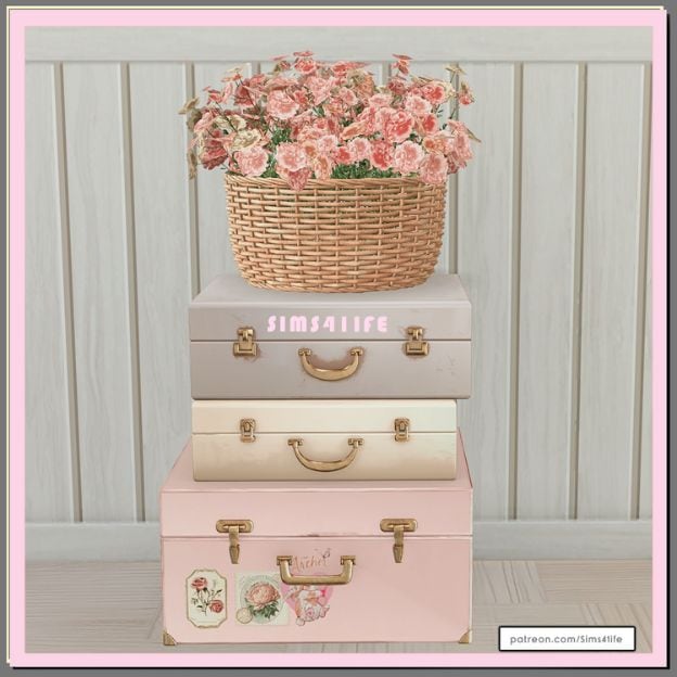 a basket of flowers sitting on a stack of three suitcases