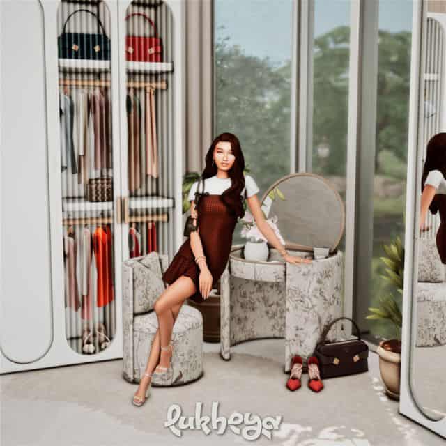 female Sim standing at a vanity table inside their wardrobe